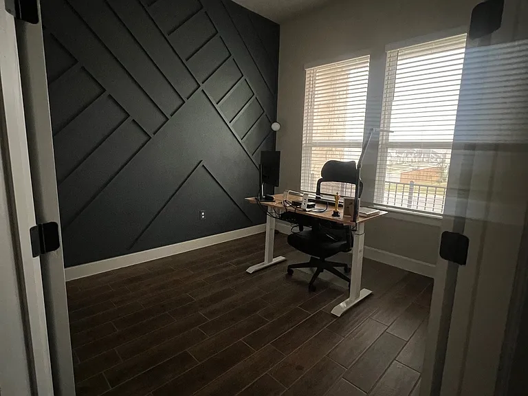 Spacious home office with abundant natural light, stylish board and batten accents, and plenty of room to work or create_perfect for productivity and comfort.
