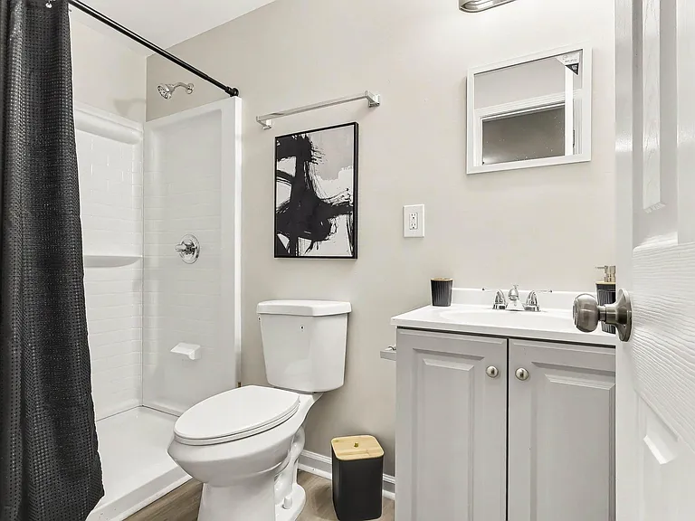 Full bathroom with a tub/shower combo, vanity with storage, and a wall mirror for daily routines.