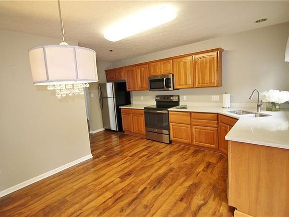 A stunning kitchen and dining area with natural cherry cabinetry, new quartz counters that you have to see to appreciate and new
