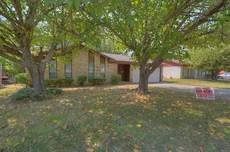 Tree-shaded brick home with 2 car garage