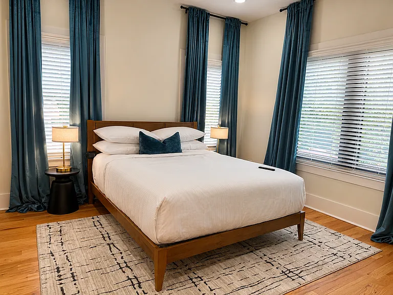 Get the best sleep in this queen bedroom with plush bedding, blackout curtains, bedside charging, warm lighting, and a smart TV to binge watch your favorite shows. Relax in luxury!