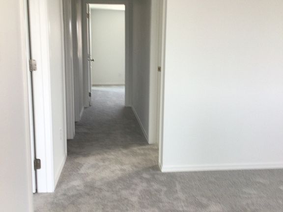 Looking from top of stairs down the hall to bedrooms.