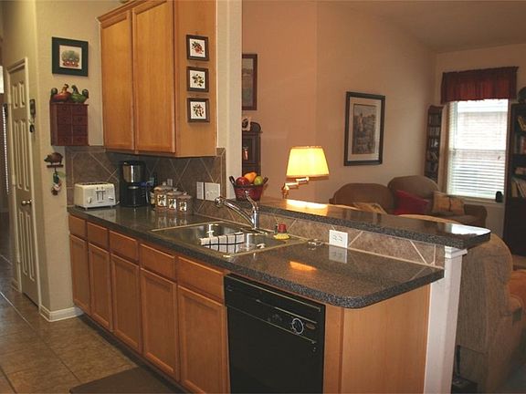 Kitchen Opens into the Living Room Separated by a Breakfast Bar