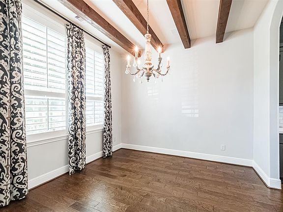 Left of the entry way is the formal dining room with wood beams and plantation shutters.