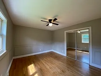 Bedroom with a ceiling fan and walk-in closet/mirror doors