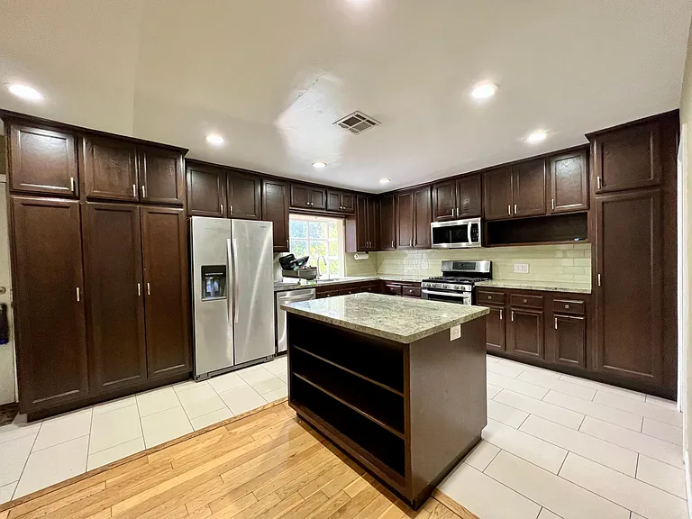Completely updated kitchen with granite counter tops, island, dishwasher, refrigerator and stove