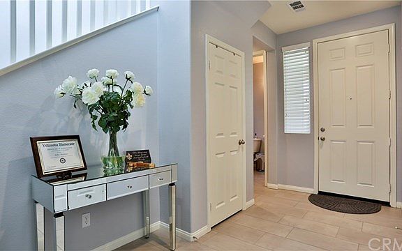 Wide entryway with 1/2 bath downstairs, hallway closet and porcelain tiled flooring