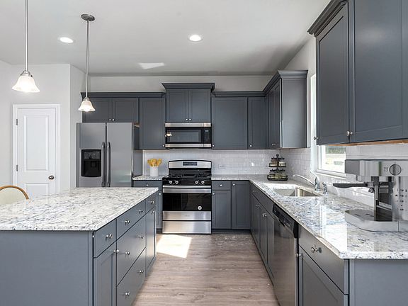 Prepare meals in the kitchen with timeless granite countertops and unique features.- Model Represent