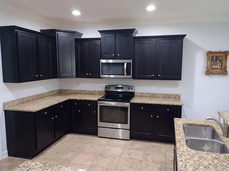 Spacious kitchen with ample cabinet storage, granite-look counters, and stainless steel range with over-the-range microwave.