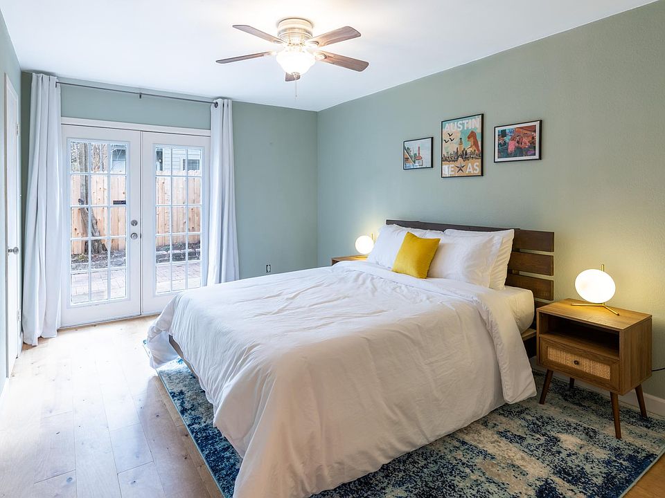 The primary bedroom features a large walk-in closet and french doors leading out to the back yard and patio with a native plant garden.