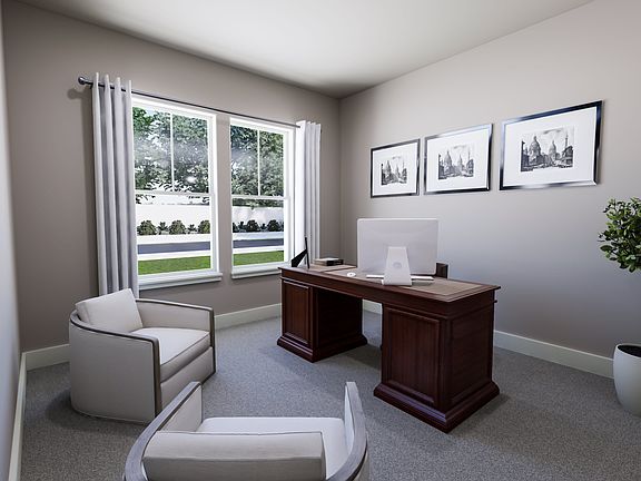 A cozy home office with a large window overlooking a lush outdoor landscape, featuring framed artwor