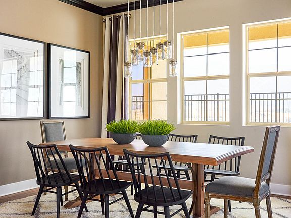 Cafe just off the kitchen is well-lit with a decorative lighting fixture and bright windows.