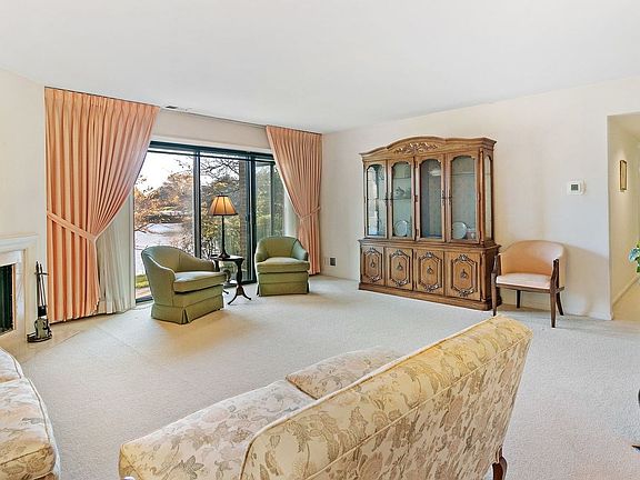 The gracious 18x17 living room is carpeted and neutral with patio doors that let in so much light. T