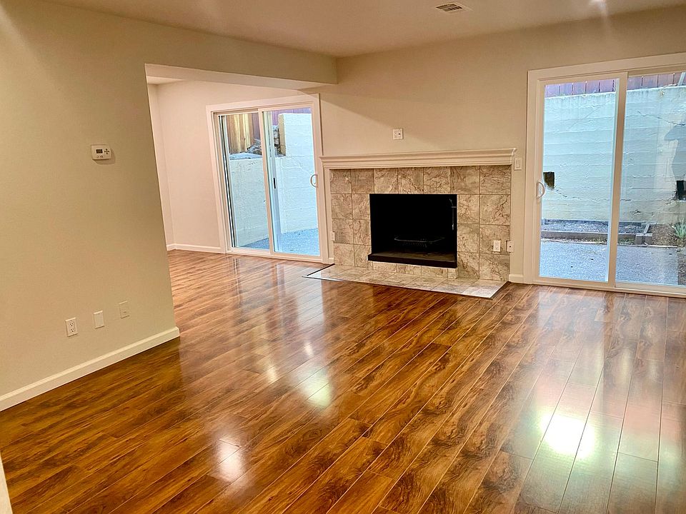 Living room with fireplace and dual sliding glass doors leading out to backyard patio.