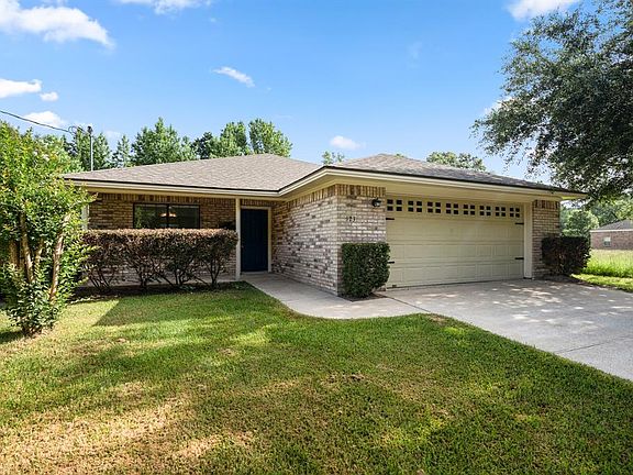 Lovely green bushes frame either side of the garage & along the front porch allowing for privacy. The exterior of the home was power washed recently in 2021 making the multi-tone bricks stand out like new!