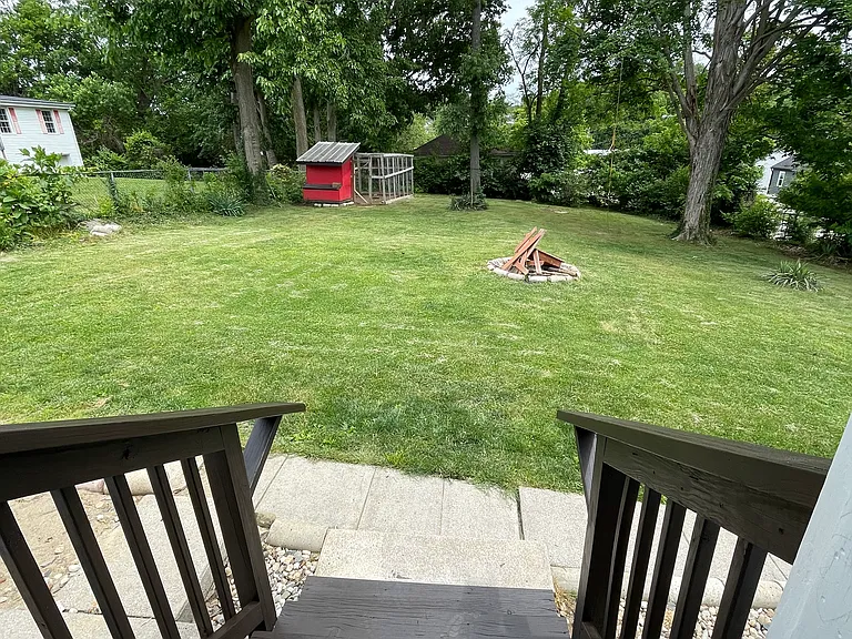 Back door steps out into large backyard with fire pit and a chicken coop!