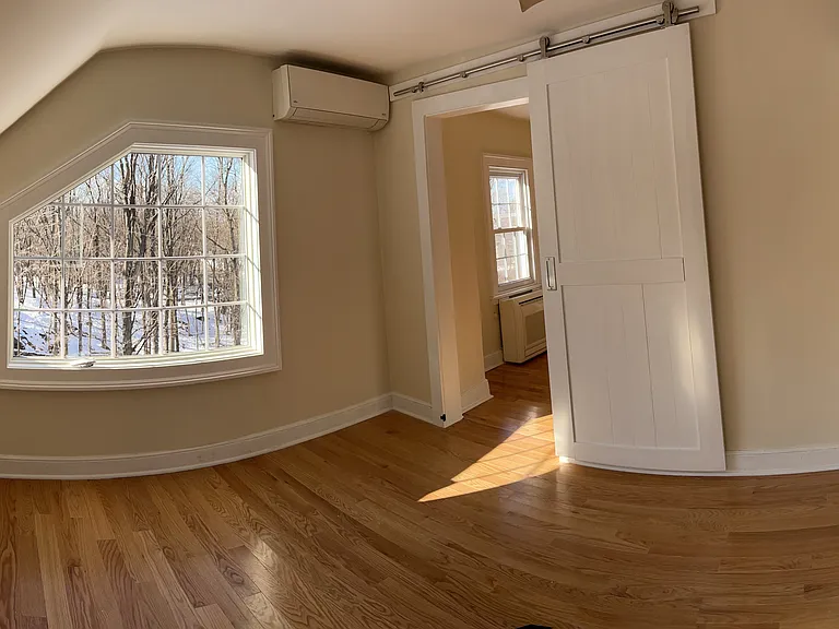 Bedroom with oversized window and barn door.