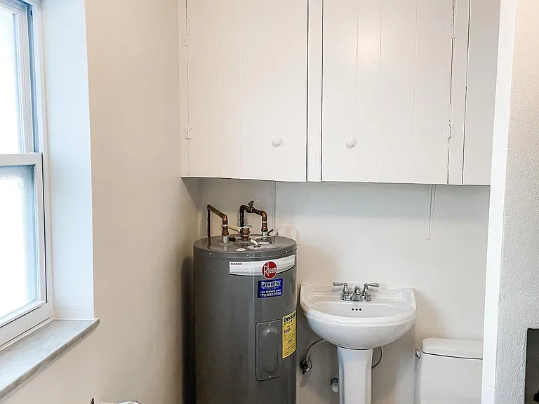 Another view of half bath/laundry room. Lots of cupboards for storage. Everything was just painted.
