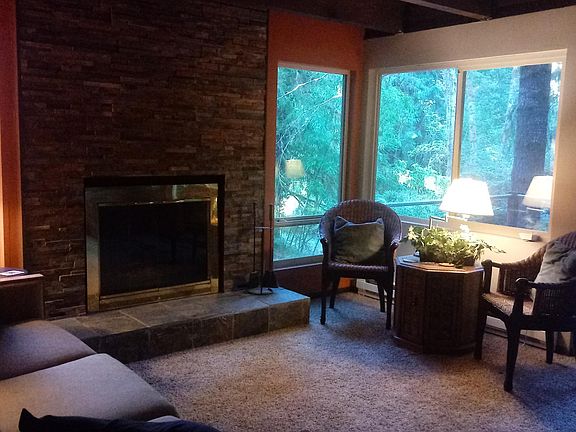 Living Room has fireplace and deck overlooking stream