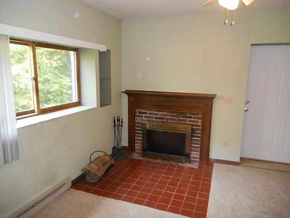 Living Room with side exit, newer carpeting and fireplace.