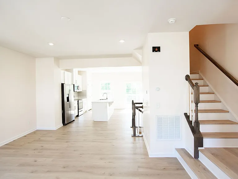 Living room with view of kitchen and stairs to 3rd floor
