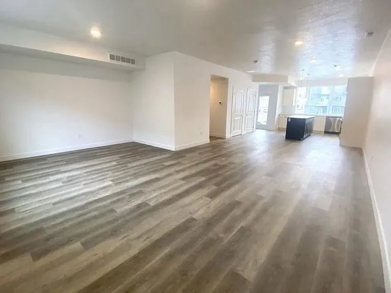 Spacious great room: living, kitchen with large island, and dining areas with LVP flooring.
