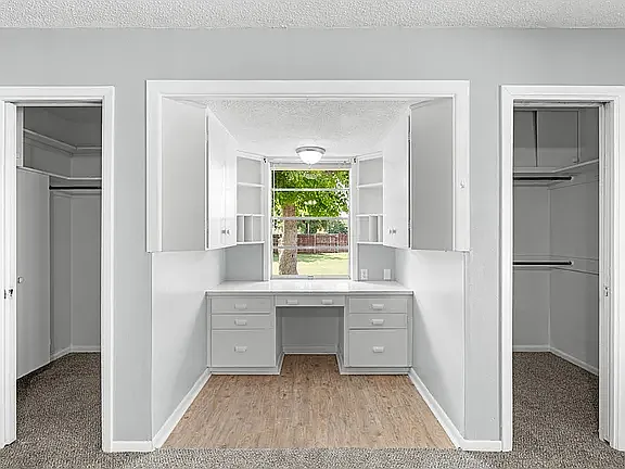 View of Desk/Office area and walk in closets in Primary bedroom, with view to large back yard backing up to Methodist Encampment Road (no neighbors behind you or on the left side of duplex)