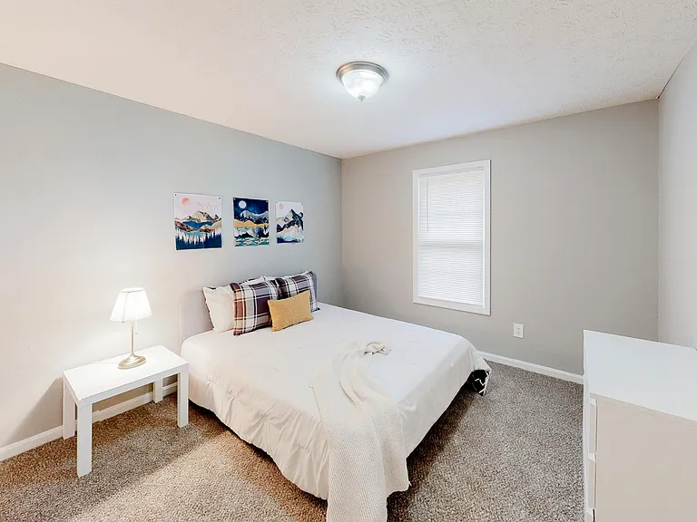 Spacious bedroom featuring a queen bed, nightstand, dresser and reach-in closet.