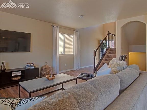 Living room ...stairs leading upstairs to 3 bedrooms and arch leading to the basement