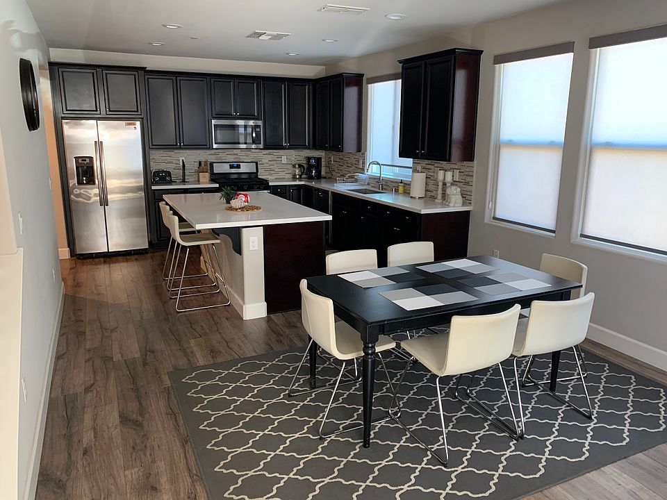 Fully stocked kitchen with two barstools. Dining table sits 6.
