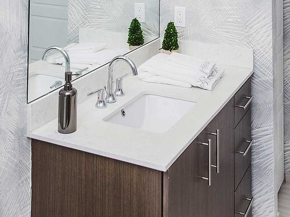 Quartz countertops and dark cabinetry with chrome pulls