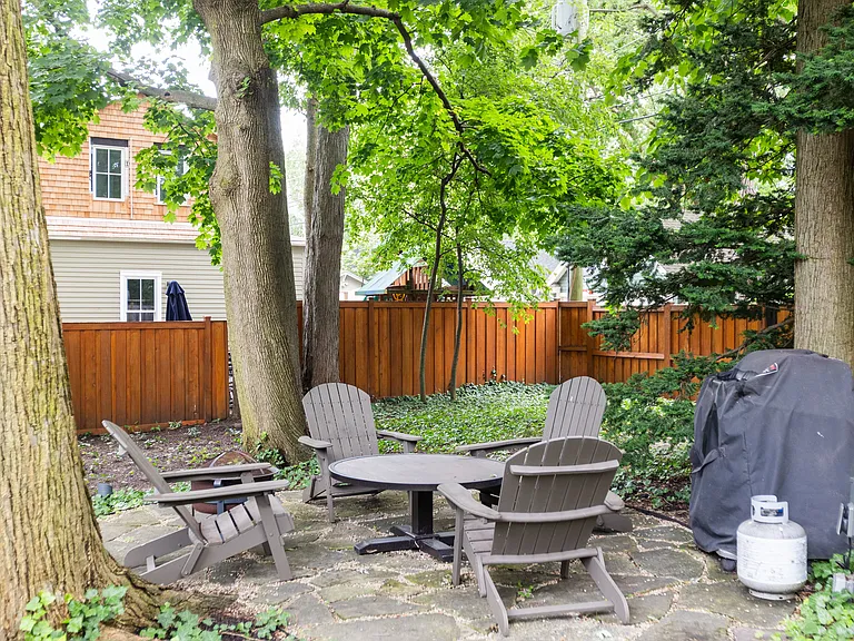 Tenant outdoor patio underneath a forested private area at the rear of the home.