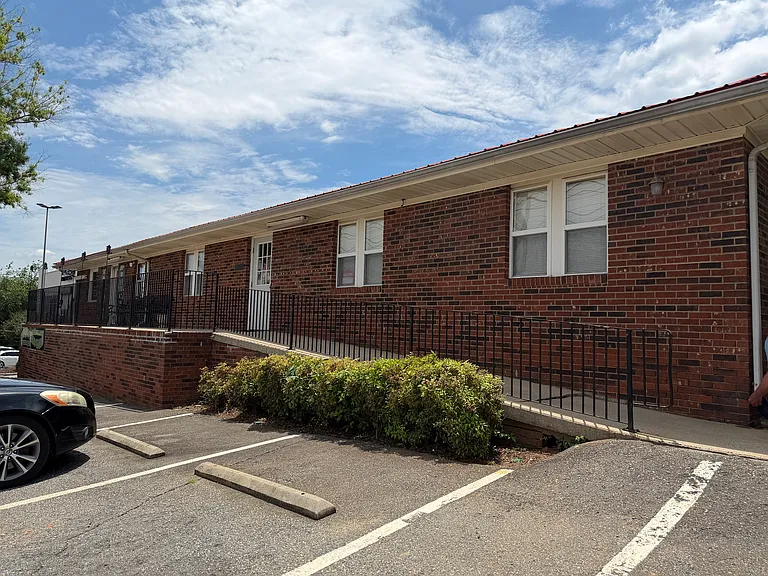 Street-facing brick commercial building with dedicated front parking. Neat, structured exterior with a clean layout, exuding positive vibes and good feng shui orientation for business prosperity.