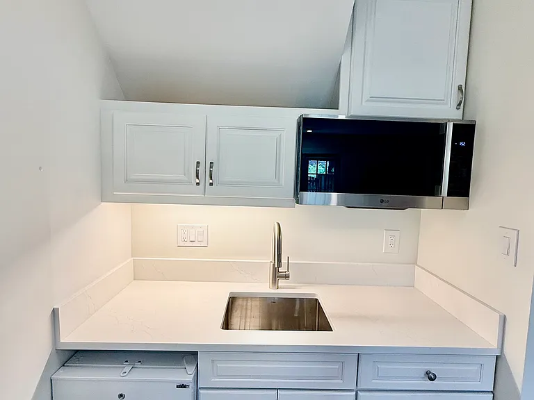 Brand new kitchenette with all new appliances (refrigerator, freezer, microwave, sink and cooktop).
