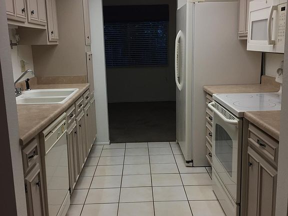 Full kitchen (foreground) with view toward dining area (background).
Updated appliances: refrigerator, glass top stove/oven, microwave, dishwasher, sink, and disposal. Refrigerator is 25.3 cu. ft. side by side with filtered water and ice dispenser