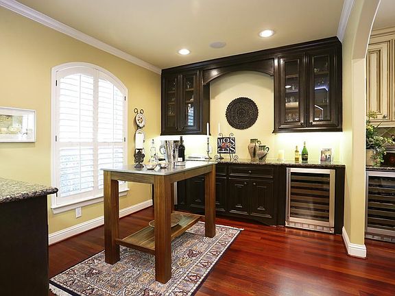 Butler's pantry/ wine room, conveniently located between kitchen and dining room with gleaming hardw