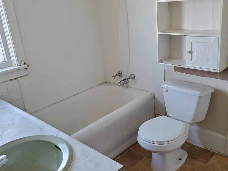Bathroom is accessed from front hall and kitchen