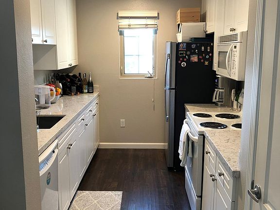 Updated laminate flooring with brand new stainless steel refrigerator, full pantry on the right.