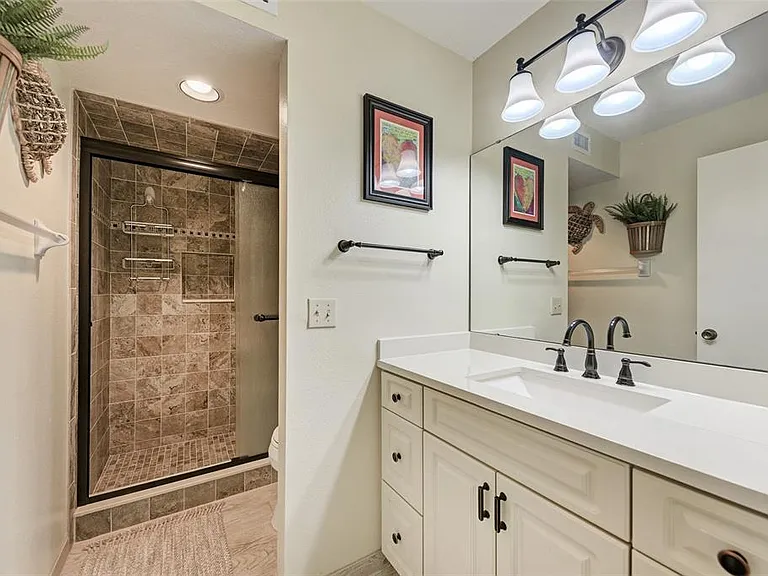 Clean, modern, and coastal. __ Enjoy the beauty of our upgraded primary bath. Featuring a gorgeous walk-in shower with designer tile, it's just one of the many ways we've made Unit 1003 feel like a true retreat.
