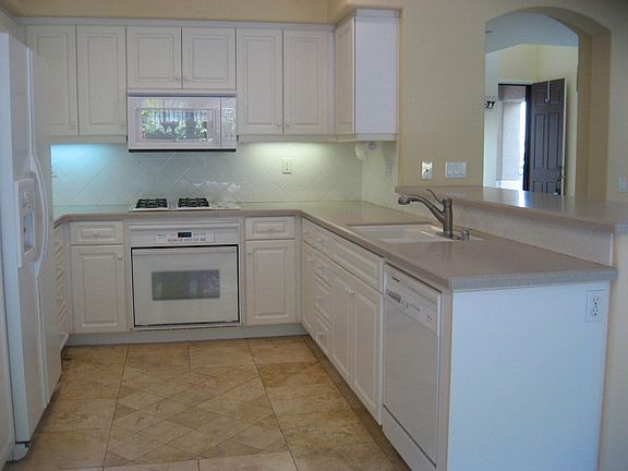 Kitchen with travertine floors, Corian counters