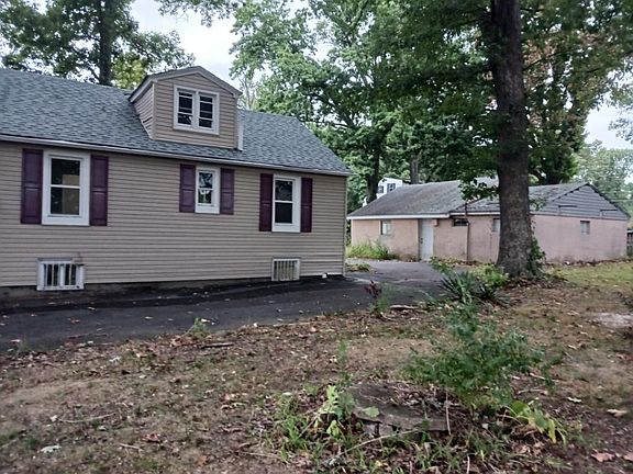 Back of home with view of detached 2 bay car garage