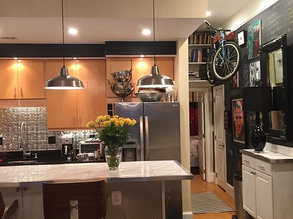 Chalk wall to hang your gallery art and even your bike! Above door space saving book shelves.