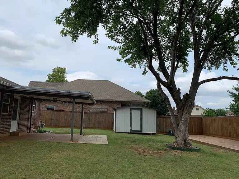 Back covered patio with fan and large
storage building