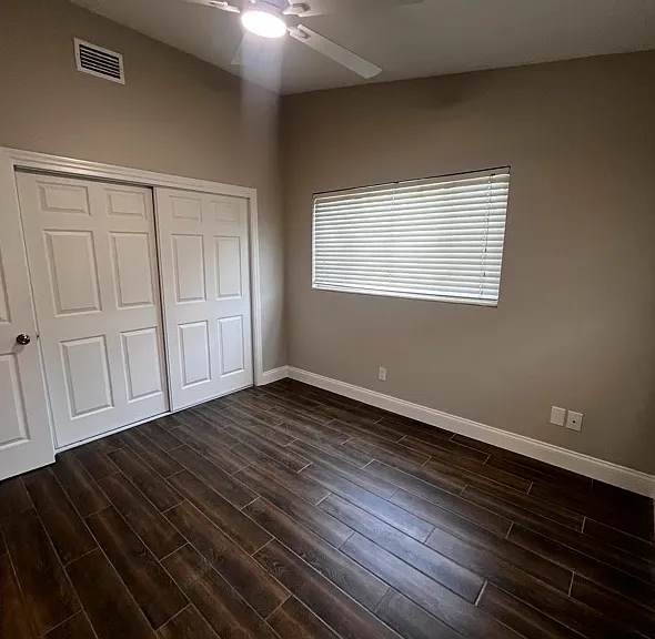 Bedroom #2: Ceiling fan with light, closet, wood look porcelain flooring.