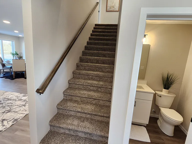 Stairs leading to upstairs living spaces. (Pictures are of another unit with similar finishes and features.)
