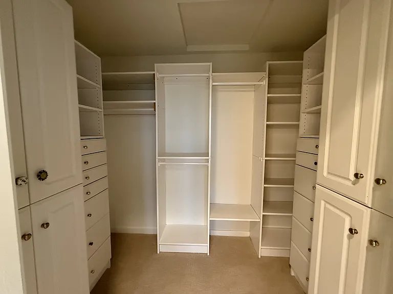 Spacious primary walk-in closet with built-in organized storage.