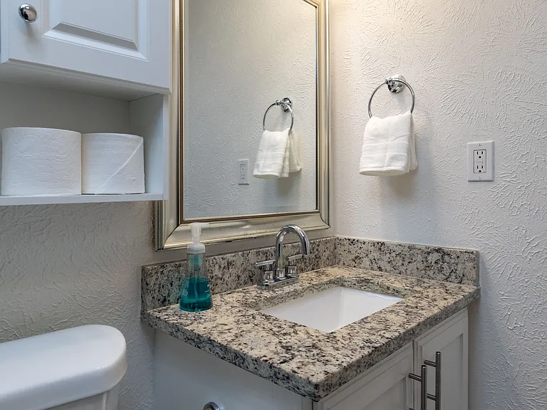 Bathroom 2 offers a convenient tub/shower combo stocked with shower gel, shampoo, and conditioner, plus a cabinet-style sink for added storage and functionality.