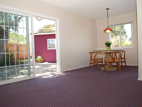 View looking out large sliding door toward backyard and 2-car garage
