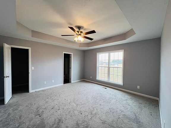 Main bedroom has a trey ceiling with ceiling fan