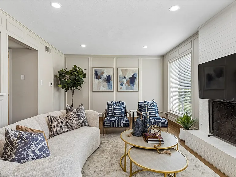 Living area featuring recessed lighting, panel molding accent walls, large windows with blinds, and a white brick fireplace